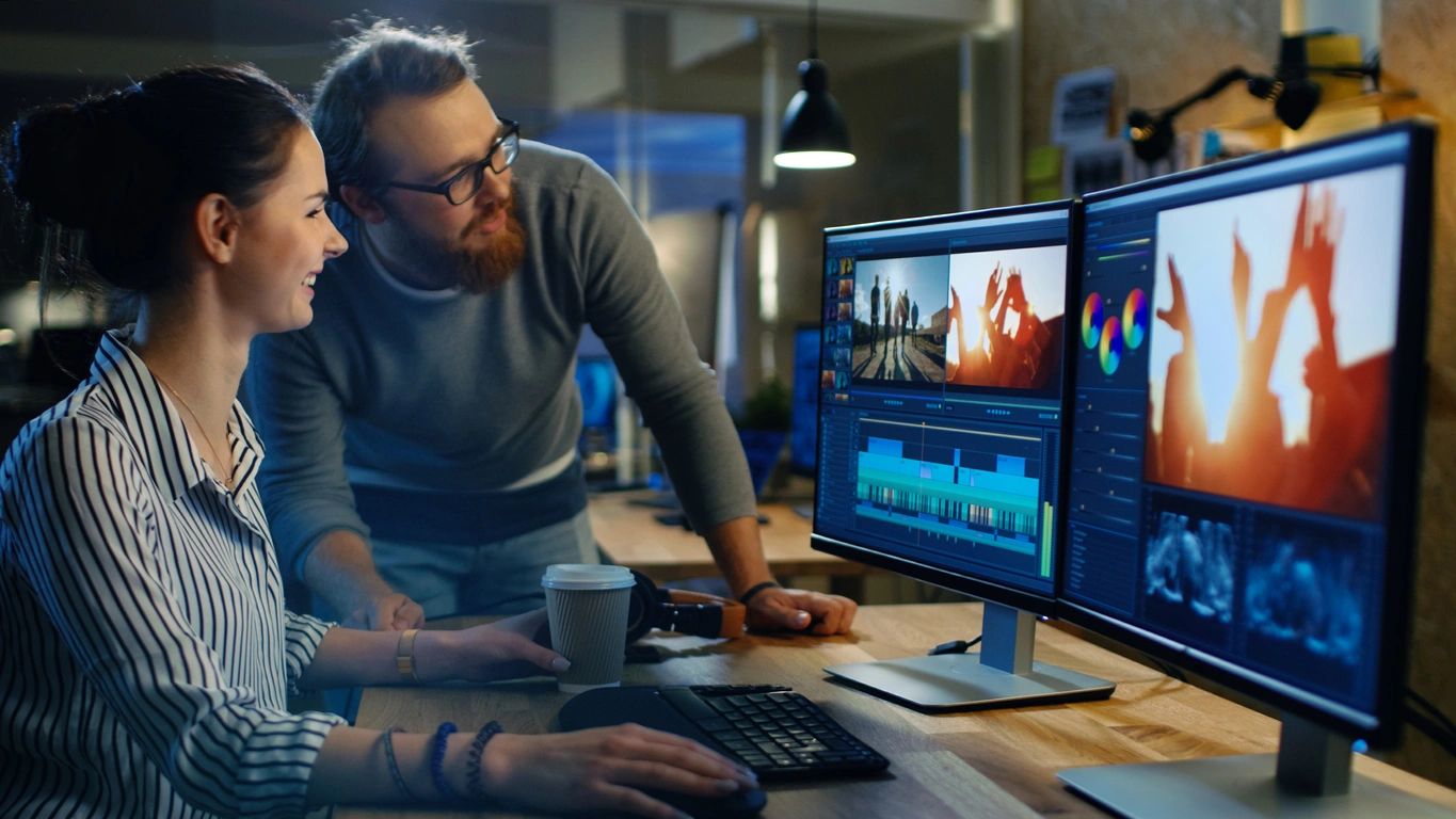 A man sitting at a desk with two monitors.